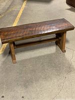 Full view of the handcrafted wooden bench showing seat and base