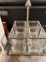 Front view showing brushed nickel frame and four clear glass square compartments.