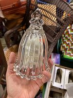 Hand-held clear glass Christmas bell ornament with fluted body and Christmas tree-shaped top.