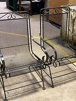 Pair of vintage metal garden chairs side by side showing overall design and construction.