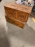 Pair of vintage wooden toy boxes stacked, showing Wild West text and imagery.