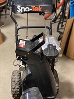 Side view showing the chute for snow discharge and part of the gas engine.