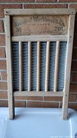 Full washboard showing wooden frame, tin corrugated panel, and six vertical wooden ribs.
