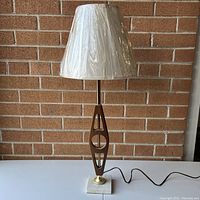 Full view of the vintage MCM table lamp with replacement shade showing teak wood body, brass accents, and white marble base.