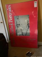 Framed poster leaning against a yellow wall showing overall size and condition