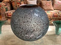 Front view of entire spherical bowl on glass table with couch background