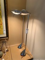 Corner view showing both lamps standing, chrome finish, cone-shaped bases