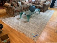 Full view of rug under coffee table and sofa showing overall size and placement.