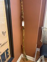 Full view of the painted rain stick showing its length, colorful paint and some texture.