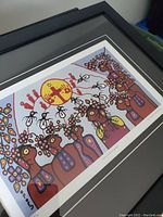 Framed colorful print by Christian Morriseau depicting abstract figures with circular yellow-red sun element, showing print and frame condition.