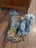 Pair of moccasins with fur lining and colorful beadwork on toes, showing upper and sole side