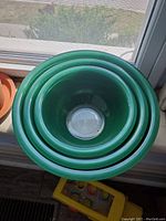 Top view of the four nesting green Pyrex mixing bowls showing their graduated sizes and nesting arrangement.