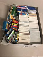 Photo of a box filled with loose white edge baseball cards and packs