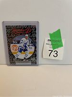 Photo of Auston Matthews hockey card in protective sleeve with MaxSold lot tag number 73 visible.