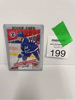 Auston Matthews rookie hockey card displayed in protective plastic holder alongside auction lot number sticker