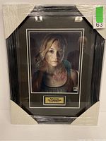 Photo of the shrink-wrapped black frame holding an 8x10 autographed photograph of Beth Greene from The Walking Dead. The autograph is in red ink and a plaque underneath identifies the character and actress.