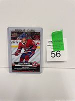 Photo of Cole Caufield hockey rookie card in protective sleeve with label and auction tag