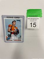 Drew Lock rookie football card #303 in a protective case labeled 'ROOKIE CARD'. Player pictured in Denver Broncos gear holding a football.