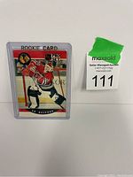 Photo of Ed Belfour rookie hockey card #598 in protective sleeve with auction lot tag beside it.