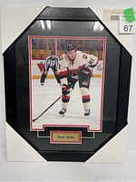 Front view of the 8x10 framed photograph of Mark Stone in Ottawa Senators uniform on the ice, inside a black angled frame with red and white double matting and a nameplate.