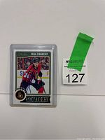 Photo showing the front of the Mika Zibanejad hockey card with autograph and protective case.