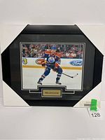 Framed 8x10 photo of Milan Lucic in Edmonton Oilers hockey uniform, displayed on a white wall.