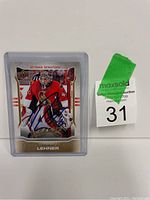 Photo shows a Robin Lehner Ottawa Senators hockey card with autograph in blue ink, inside a clear protective case, placed next to auction lot number 31.