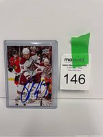Photo showing the signed Shane Doan hockey card in plastic protective sleeve with auction lot number tag visible