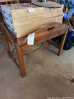 View of the coffee table from the side with cardboard boxes on top to show size and structure.