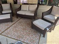 Full view of set on porch: loveseat center, armchairs at sides, two ottomans front