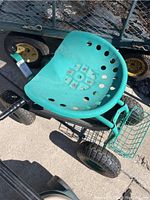 Full top view of garden cart showing green tractor seat with holes, steel frame, and front tire.