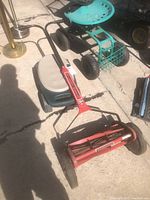 Overview photo showing the lawn mower and garden seat placed on concrete surface.