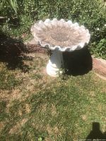 Photo of vintage concrete birdbath showing scalloped edge and fluted pedestal.