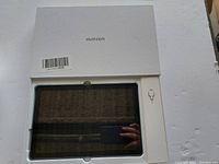 Black screen PC tablet inside white Yuangen branded box with SIM card ejector tool on the side