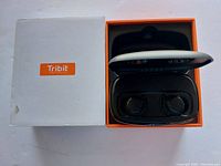 Photo of Tribit true wireless earbuds in charging case and original box.