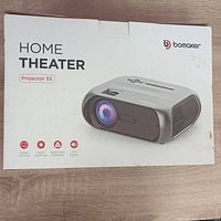 Photo of Bomaker Projector S5 box showing product image and features: screen mirroring, higher brightness, better color calibration, and built-in speaker.