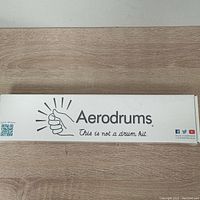 White rectangular box with Aerodrums branding and slogan on a wood surface