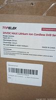 Close-up of product label on one box showing Topelek brand, model DS050A, 20V DC max, torque 35 Nm, chuck size 1/2 inch, speed settings, manufacturer details, and barcode sticker.