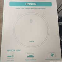 Box front showing Onson branding, model J10C with key features highlighted: ultra thin, medium carpet suitable, 2100Pa suction.