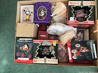 Full view of the box containing various Christmas ornaments including Coca-Cola, Mickey Mouse, Christmas Charmers, and Hallmark