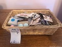 Basket containing over 50 pairs of earrings in original packaging and loose, displaying various colors and styles.