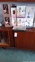 Several boxed crystal glass sets including Jean Pierre Florian Blue flutes, Bellini, Diana, and Rigoletto glasses along with clear dish visible on side.