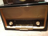 Full front view of Grundig 5010 radio showing wood cabinet, woven cloth grill, tuning knobs and push buttons