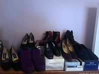 Photo of ten pairs of shoes displayed on shelves including various women's dress shoes, boots, and waterproof shoes in size 9-10.