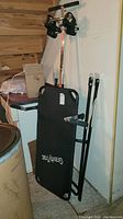 Full view of the Gravity Trac inversion table leaning against a wall showing padded surface and frame.