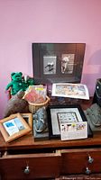 General photo showing collection of items including Beanie Babies, figurine, bookends, framed art, party cards on wooden furniture