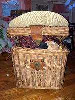 Open wicker basket showing assorted textiles and novelty items inside.