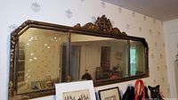 Front view of large etched glass mirror showing the ornate carved frame and beveled edges with floral etching.