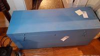 Top view of the blue wooden chest showcasing its rectangular shape and smooth painted surface.