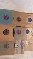 Nine 78rpm shellac records primarily featuring Benny Goodman, housed in original paper sleeves from labels including Bluebird and Columbia, showing various colored labels and wear typical of vintage records.